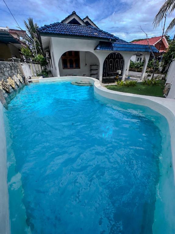 a large pool of blue water in front of a house at SM VILLA LANGKAWI full privacy home with pool in Kuah
