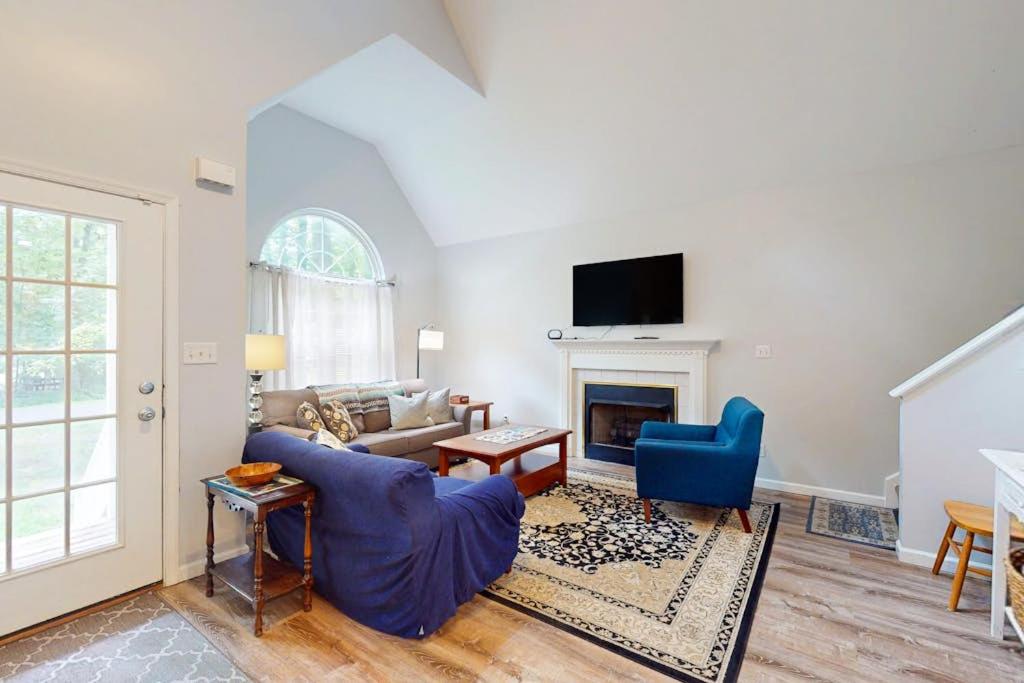 a living room with a fireplace and blue chairs at 37 Moonraker Road in Ocean Pines