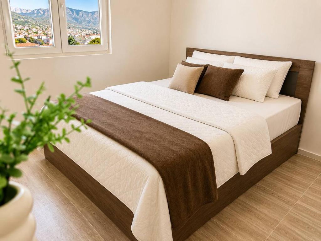 a bedroom with a large bed with white sheets and pillows at Alula Apartments 2 in Bar