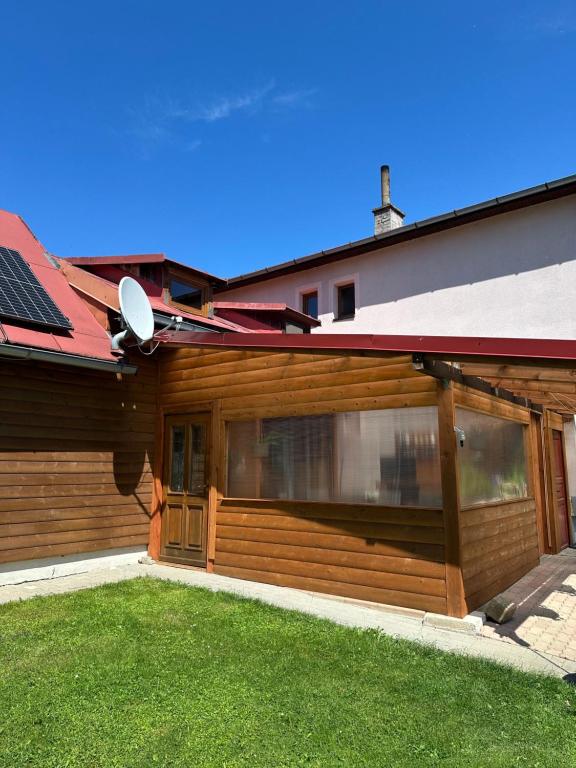 a house with a wooden garage with a satellite at Apartmán Gál 3 in Kvačany