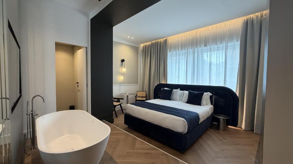 a bedroom with a tub and a bed and a bath tub at Palazzo Montella in Naples