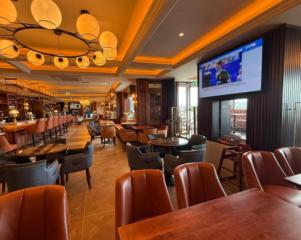 a restaurant with tables and chairs and a flat screen tv at Bayview Lodge in Downings