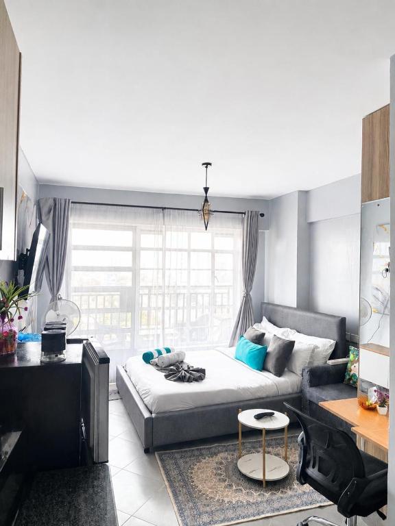 a living room with a bed and a couch at Studio Apartment with balcony in Ngara in Nairobi