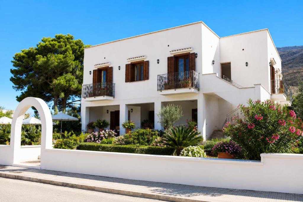 ein weißes Haus mit einem Garten davor in der Unterkunft Grimaldi B&B in San Vito lo Capo