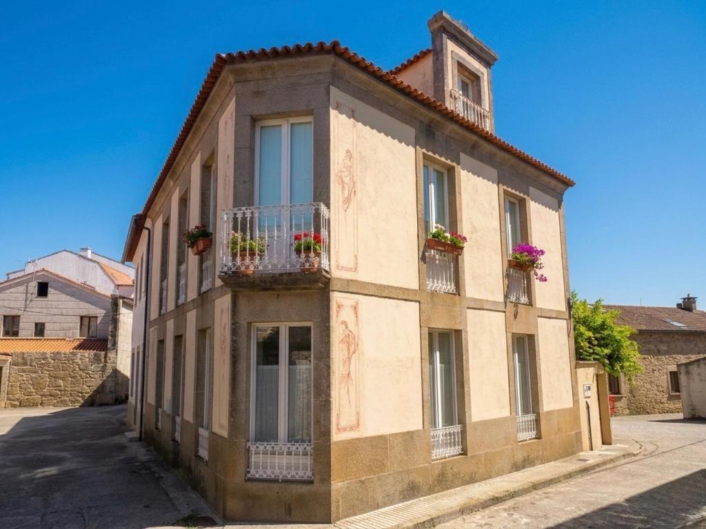 a building with flowerpots on the balconies on a street at A Casa das Nenas in Villanueva de Arosa