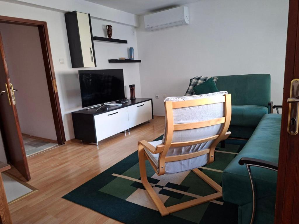 a living room with a green couch and a chair at Dama 1 in Bitola