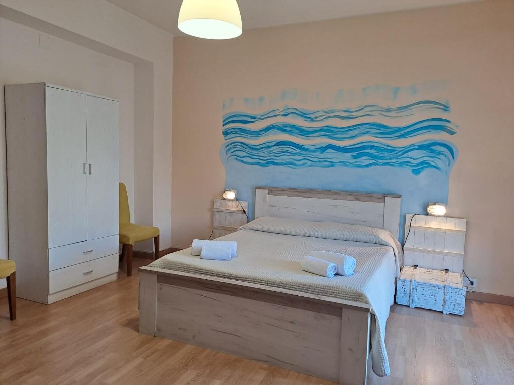 a bedroom with a bed with a painting on the wall at Medoro Piazza Roma Rooms in Milazzo
