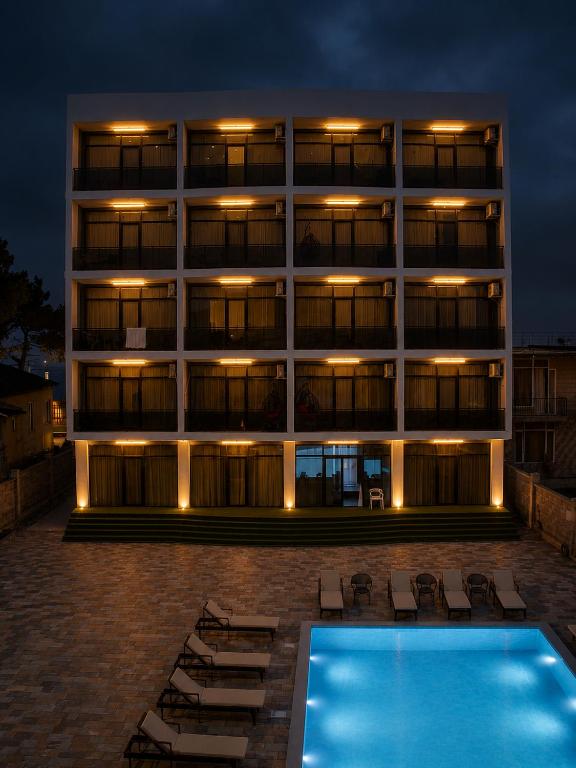 a hotel with a swimming pool in front of a building at Hotel Zich in Kobuleti