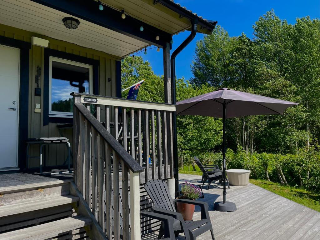 a porch with two chairs and an umbrella at Haere Mai B&B Orust in Henån