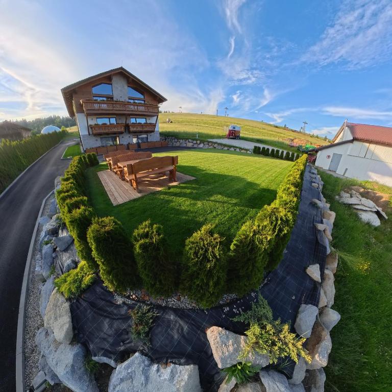 a house on top of a hill with a green yard at Apartmány Dominek in Ždiar