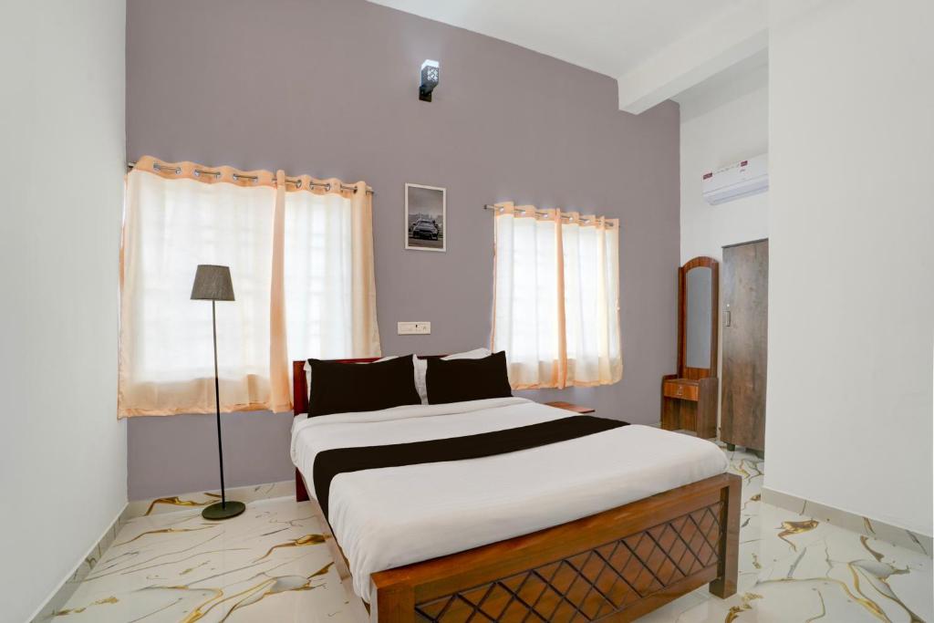 a bedroom with a large bed in front of a window at Super Hotel Redmoon Residency Elite in Chennai