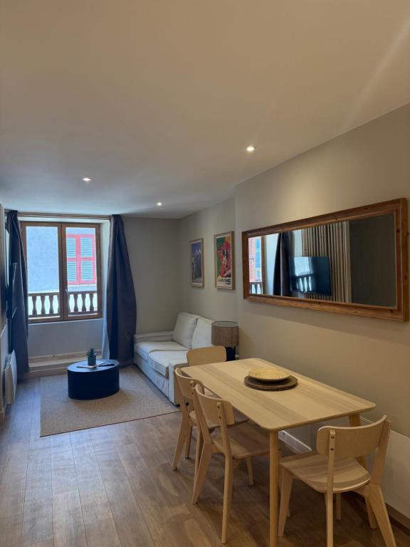 a living room with a table and a couch at Le Col Getaway Virage 6 in Le Bourg-dʼOisans