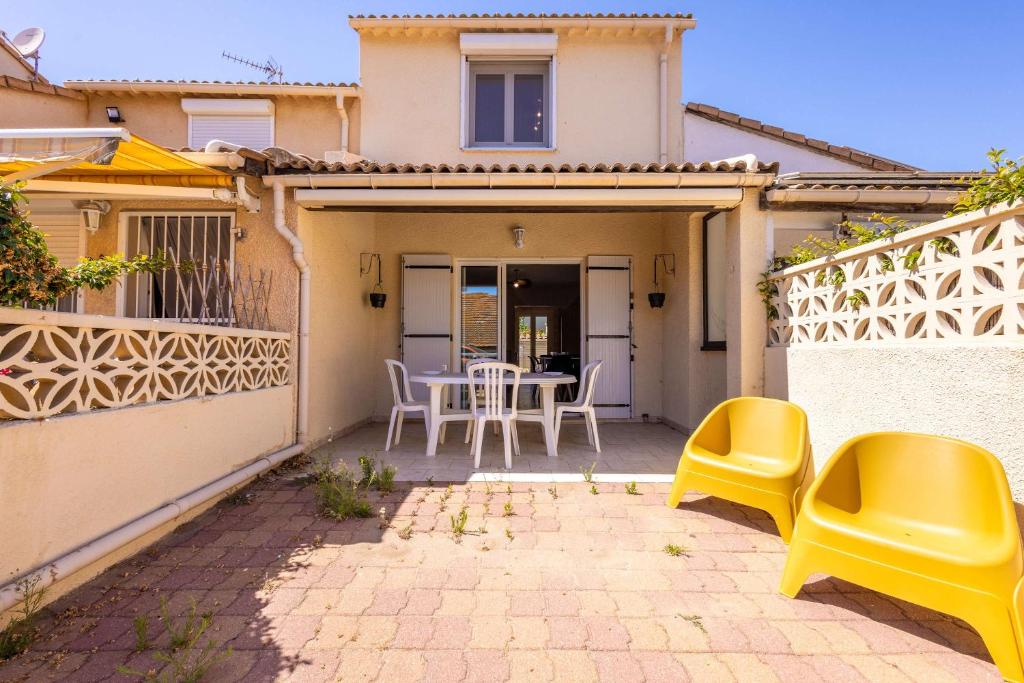 a patio with a table and chairs in a house at La Brise de Valras in Valras-Plage