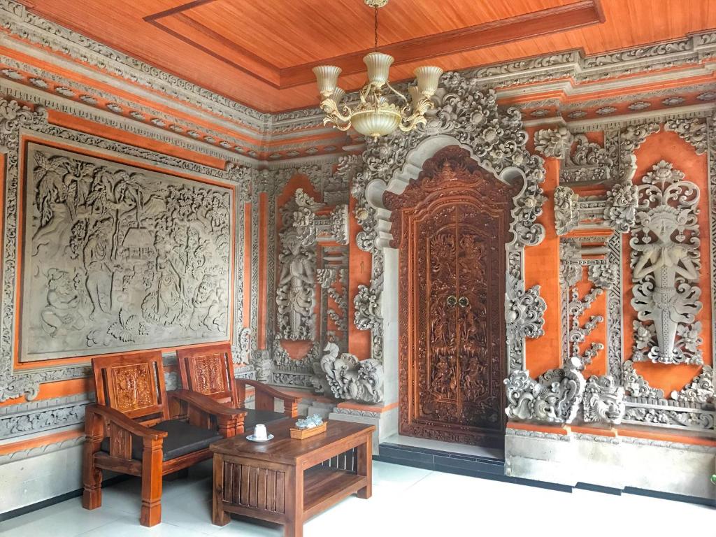 Habitación decorada con una puerta de madera y una mesa. en Sapta House en Ubud