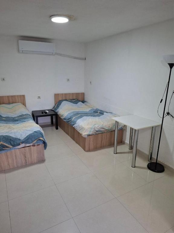 a room with two beds and a desk in it at Dama 3 in Vojnica