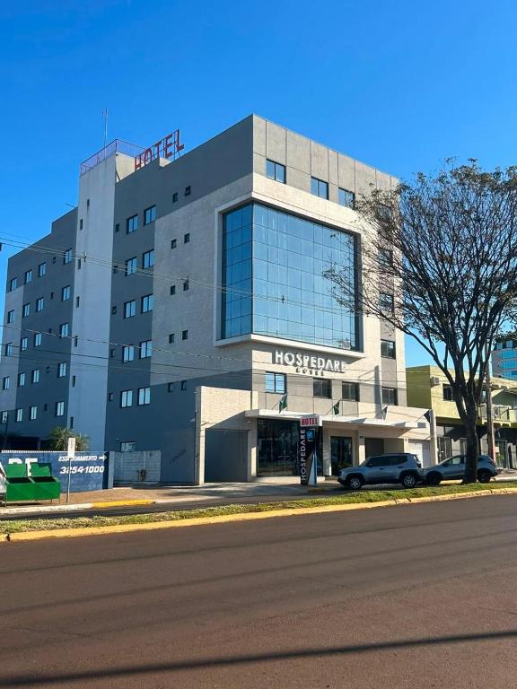 a hospital building with a car parked in front of it at Hospedare Hotel in Marechal Cândido Rondon