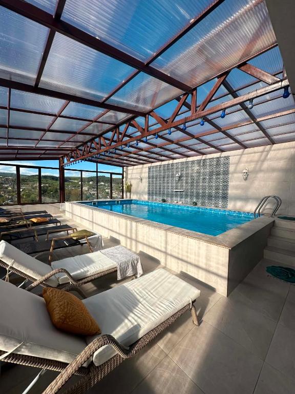 a pool with several lounge chairs and a swimming pool at Hotel Legiandro Surami in Surami