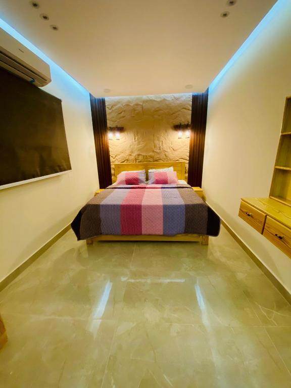 a bedroom with a bed with pink pillows on it at Emerald flat in Marsa Alam City