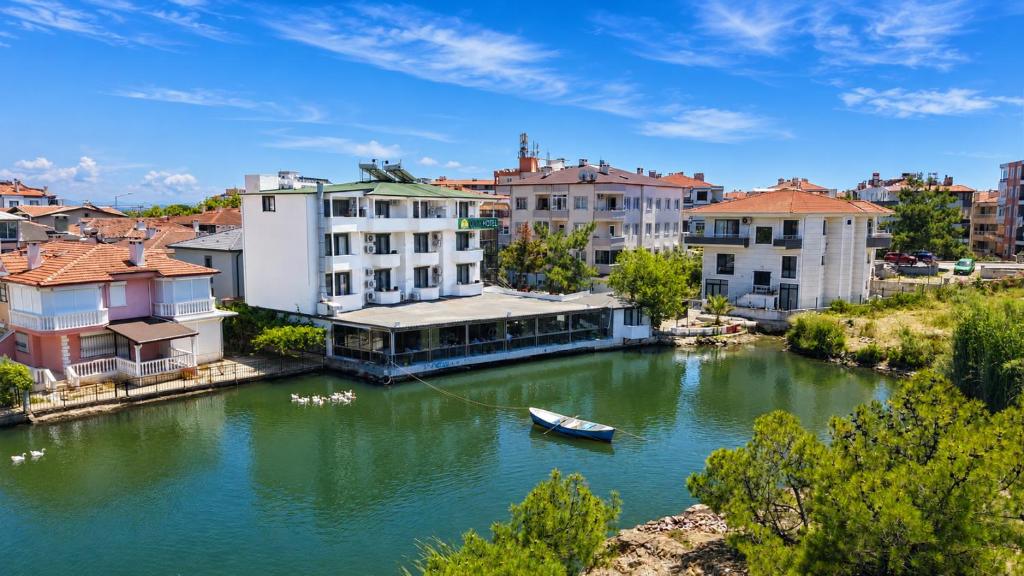 a small boat in a river in a city at Olive Branch Hotel in Ayvalık