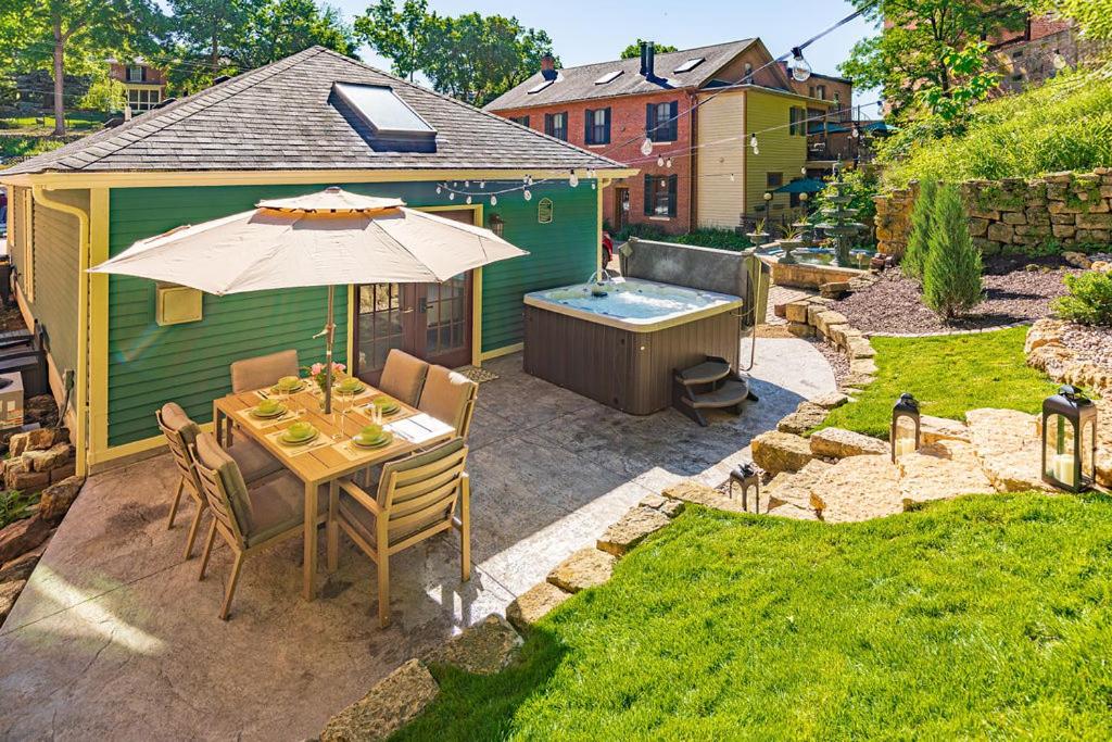 a patio with a table and an umbrella and a tub at Harvest and Hearth in Galena