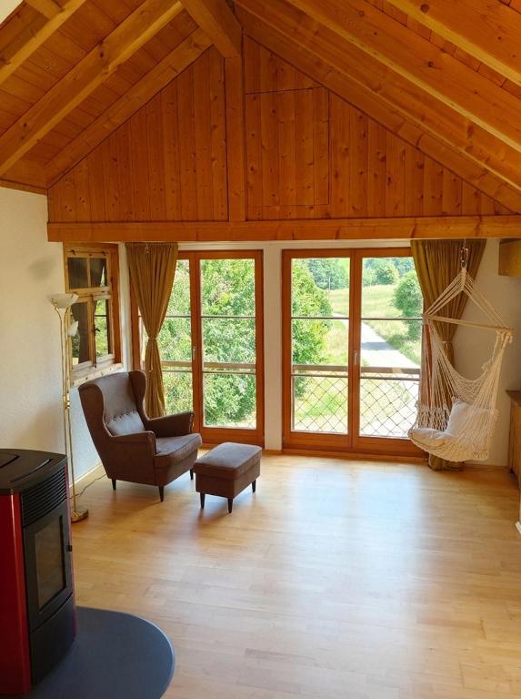 a living room with a chair and a tv at Chalet-Loft im Schwarzwaldhof Wutachblick in Bonndorf im Schwarzwald