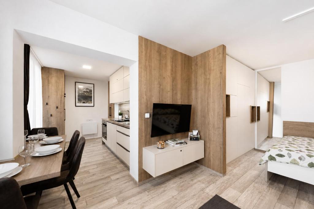 a living room with a dining table and a bedroom at Apartmány Stožec - Nella Premium in Stožec