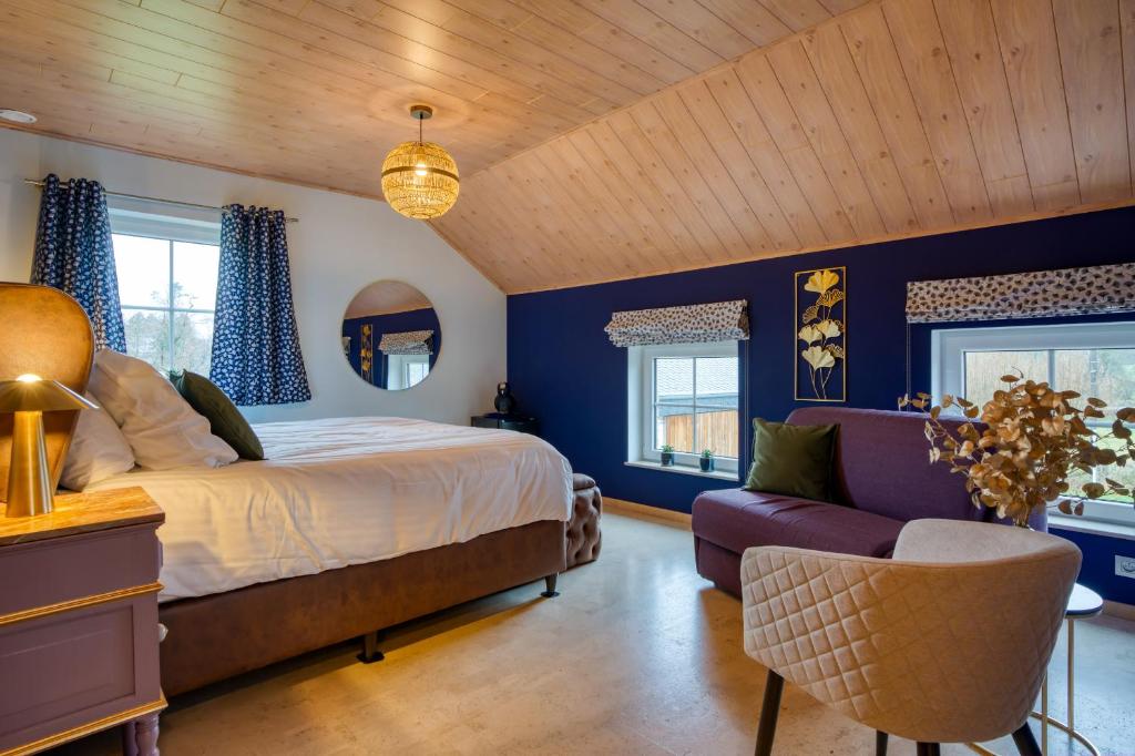 a bedroom with blue walls and a bed and a couch at Chambres Ardennez-vous in Saint-Hubert