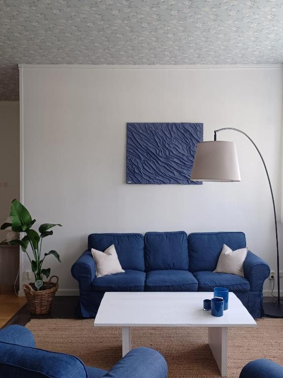 a living room with a blue couch and a table at Det Gamla Postkontoret in Råda