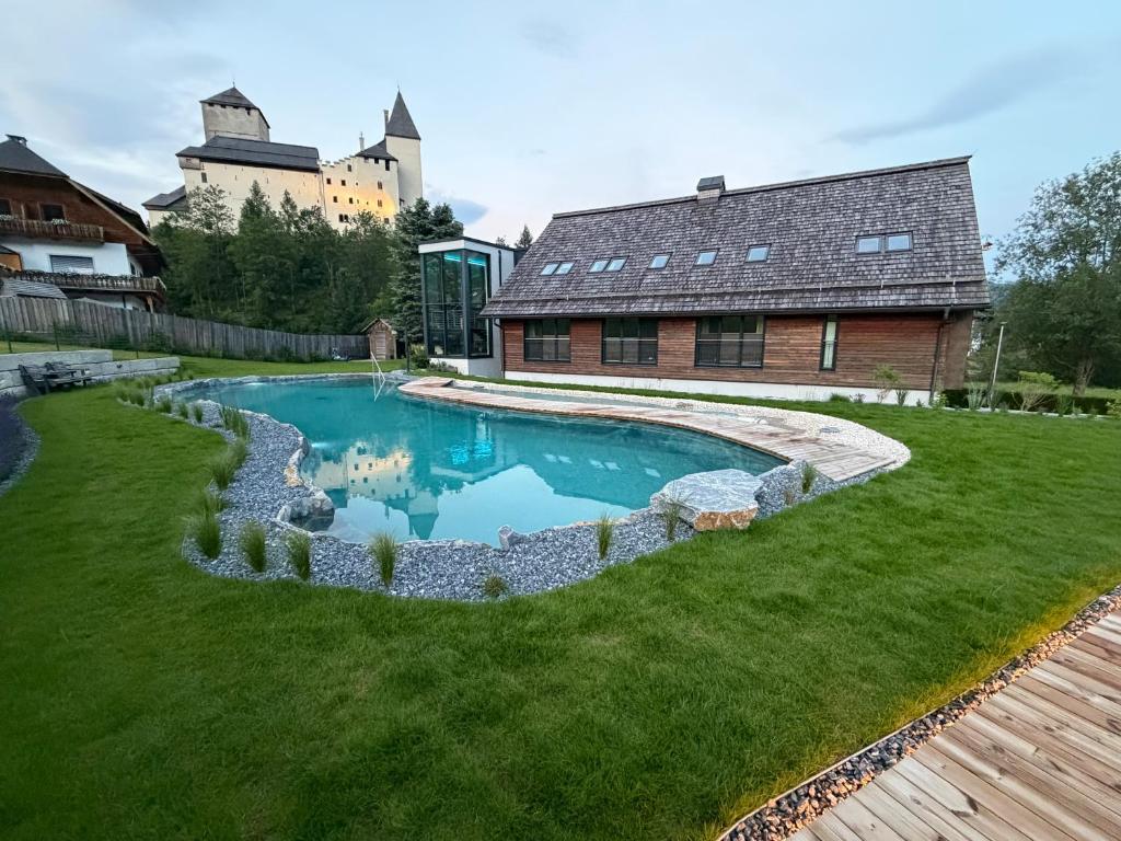 a swimming pool in the yard of a house at Residenz zur Hackenschmiede in Mauterndorf
