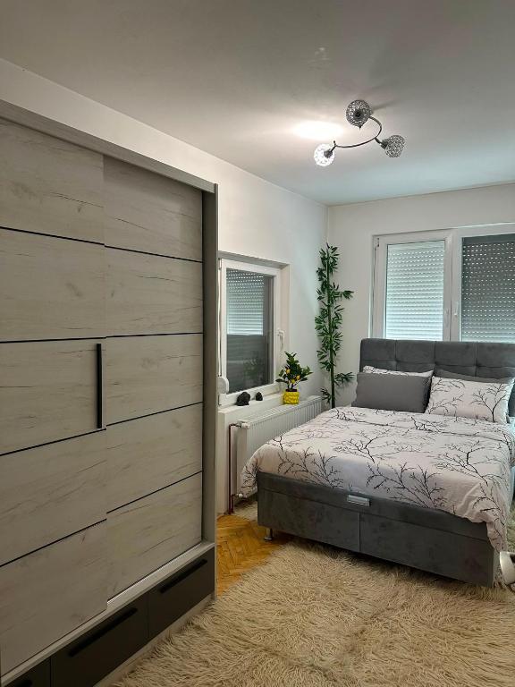 a bedroom with a bed and a large wooden closet at Sobe Andjela in Arilje