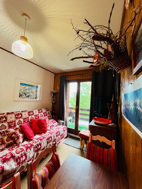a living room with a couch and a table at Studio Cosy - Le Grand-Bornand in Le Grand-Bornand