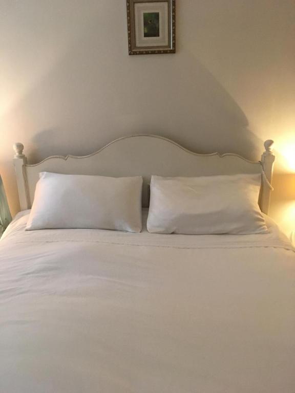 a white bed with two white pillows on it at Mountain Way in Dublin