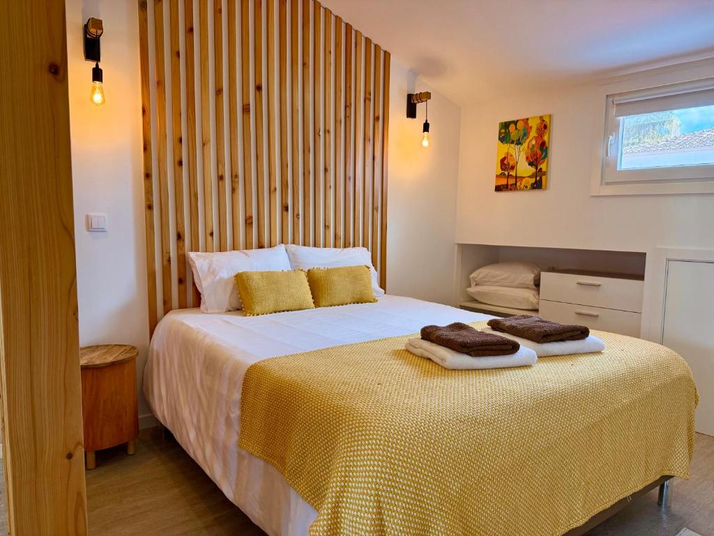 a bedroom with a bed with two towels on it at Ripado Loft in Ponta Delgada