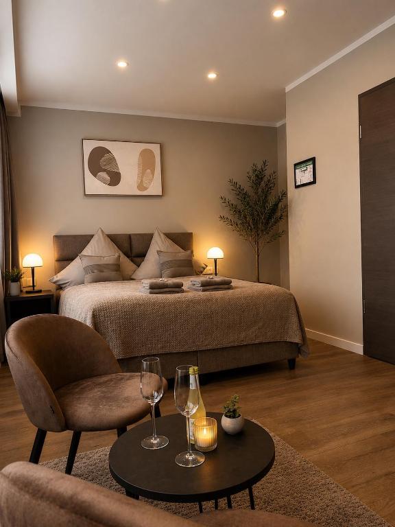 a bedroom with a bed and a table with wine glasses at StadtBlick Hotel in Bad Salzuflen