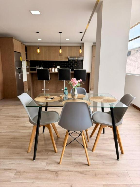 a dining room with a glass table and chairs at Departamento CENTRICO CENTRO LOJA in Loja