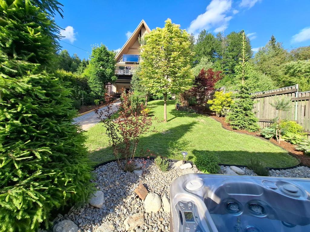 a garden with a house in the background at Chalupa Varechovsky potok in Vysoká nad Kysucou