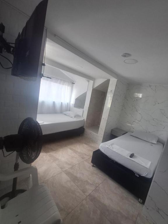 a small room with a bed and a mirror at Posada El Carro Amarillo SAS in Floridablanca