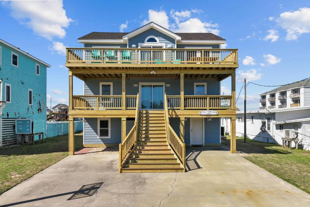 a large house with a deck and stairs on it at 5319 - Day Dreamz in Kill Devil Hills