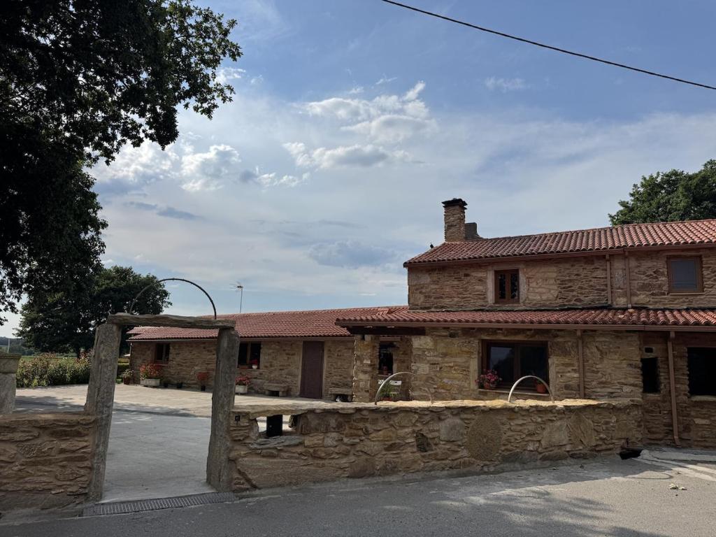 an old stone building with a gate in front of it at Casa Estraviz in A Coruña