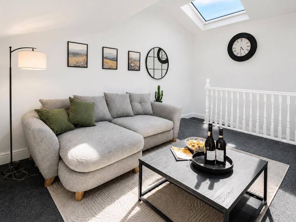 a living room with a couch and a table at Cosy Coach House - Belfast in Belfast