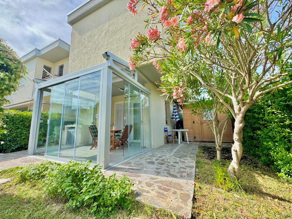 a glass extension of a house with a tree at Casa Lido in Lido Adriano
