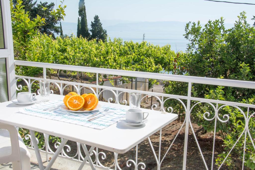 a white table with two oranges on a balcony at Spiti Kritikos in Benitses