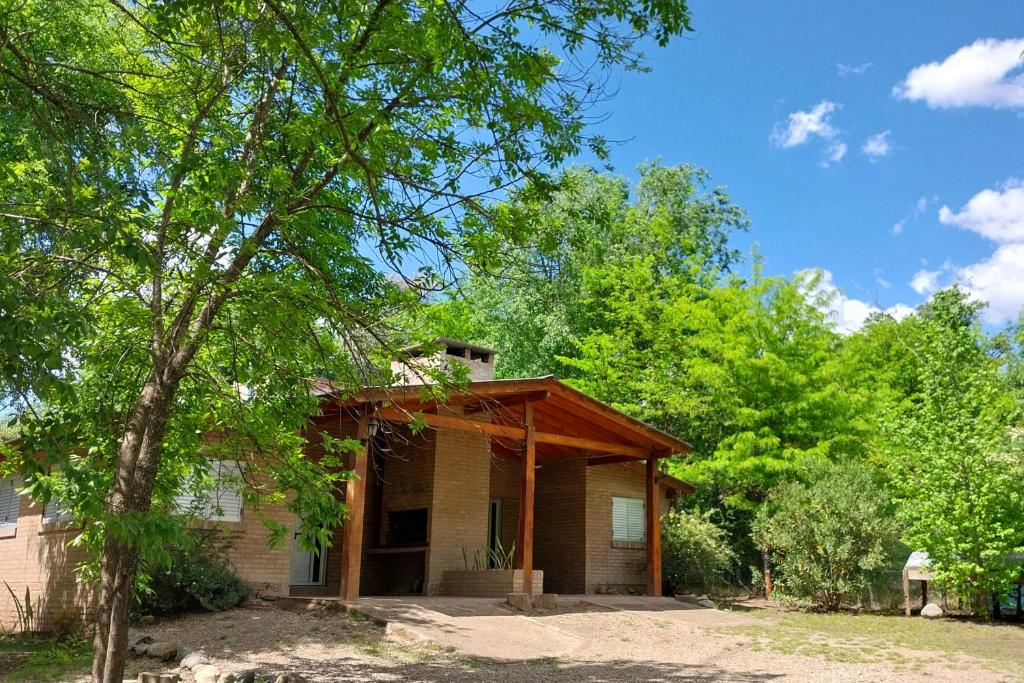 a small house with a tree in front of it at Cabañas MACONDO in Villa Ciudad Parque