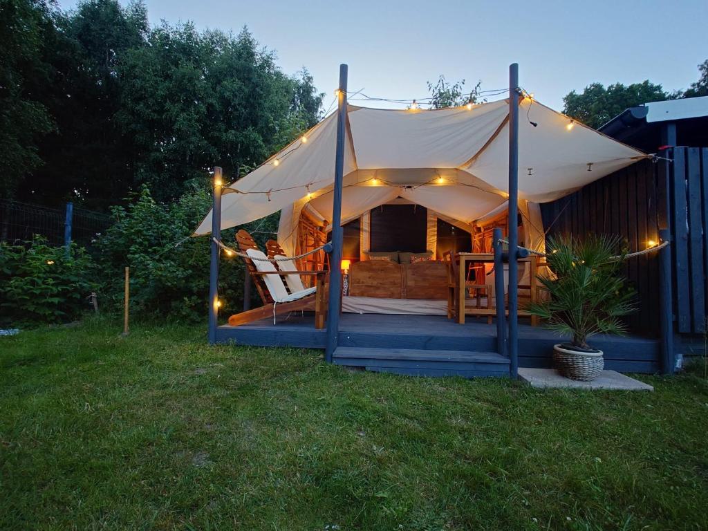 a tent with a chair in a yard at night at Zapach Morza - A Casa Mia in Niechorze