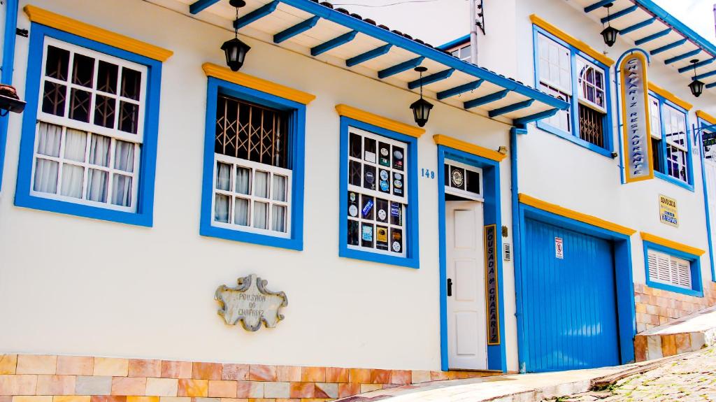 ein Gebäude mit blauen Türen und Fenstern in der Unterkunft Pousada do Chafariz in Mariana