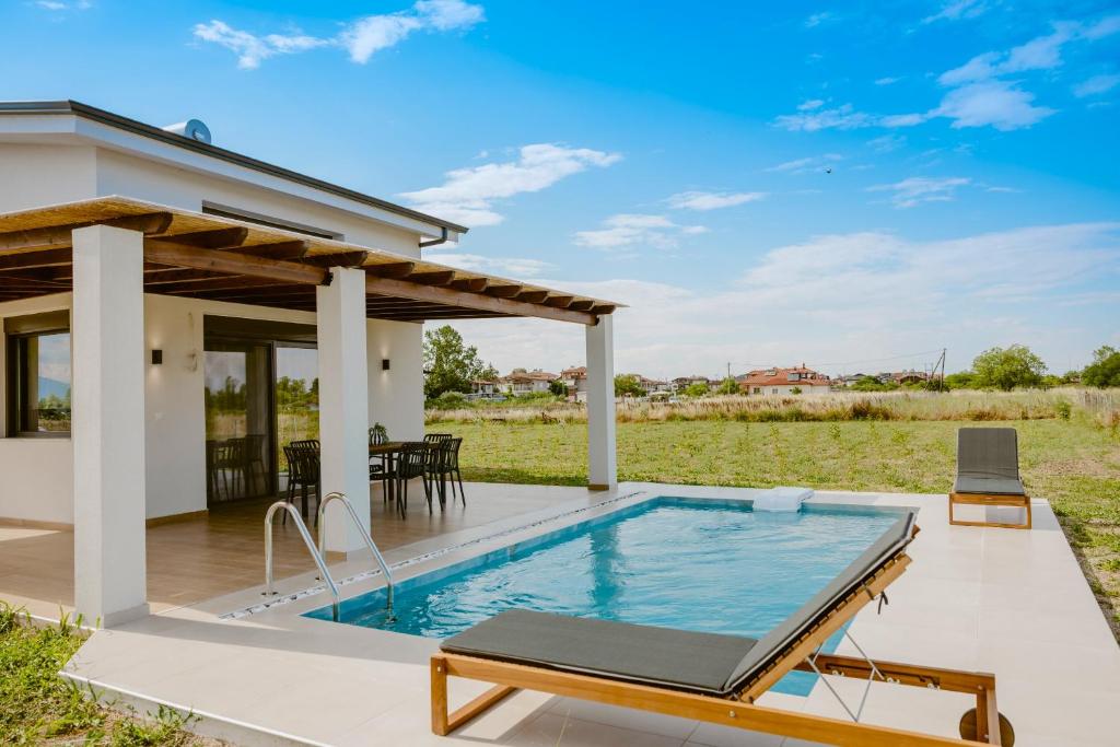 a patio with a swimming pool and a house at Nerina House in Paralia Katerinis