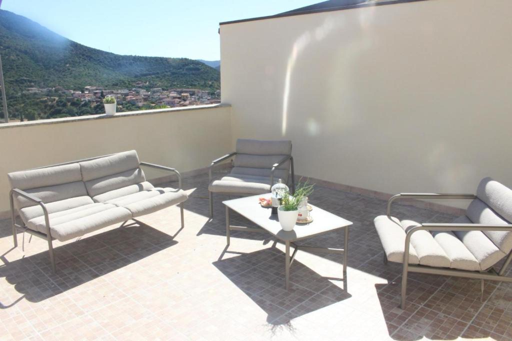a patio with two chairs and a table on a roof at Casa Elena Floris in Teulada