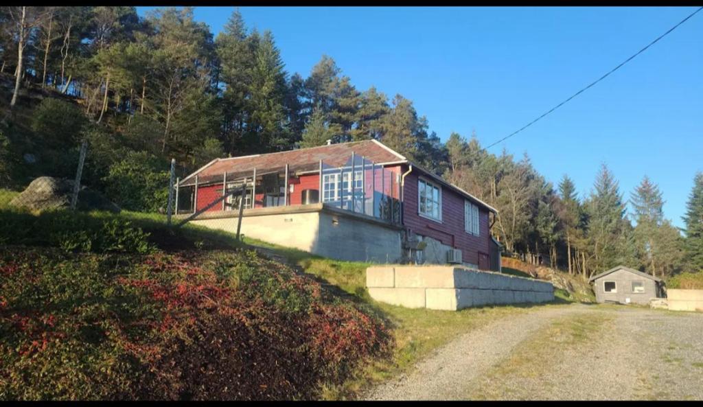 a house on top of a hill with a dirt road at Cabin and Guest house in Haugesund
