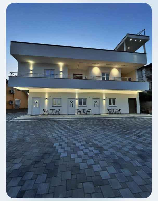 a large white building with benches in front of it at Sunlake Villa in Tirana