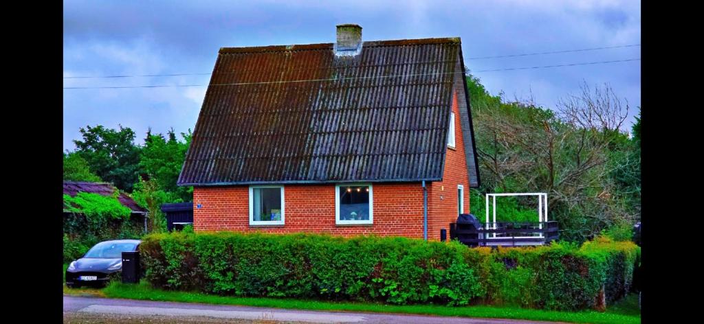 a red brick house with a black roof at Casa Tolne in Sindal